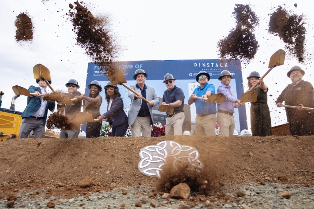 PINSTACK, Kincora, and TRITEC team members tossing dirt with shovels during the groundbreaking ceremony.