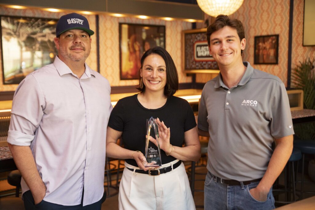 Kevin Weeks, General Manager, and Hilary Kludt, Director of Sales, of Electric Shuffle Chicago, with Bryce Hill, Project Manager at ARCO/Murray, who led the project's construction delivery.